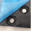 Sheet of black plastic castellated egg crate panel with secured pipe used for screed underfloor heating system