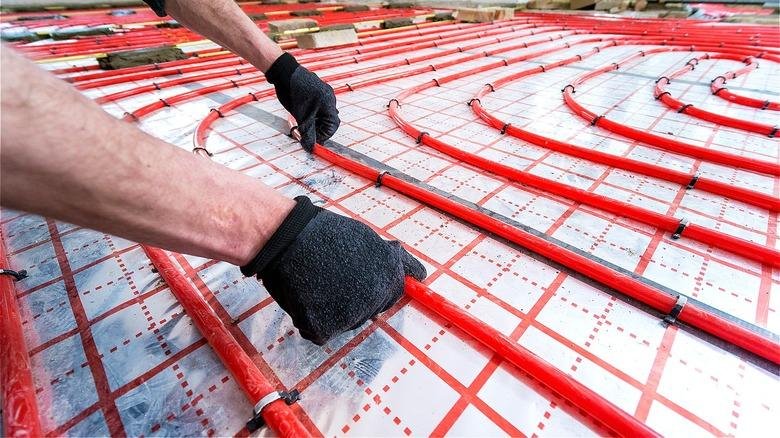 Installing red underfloor heating pipes with correct pipe spacing to ensure even heat distribution and efficient heating performance. Avoid Underfloor Heating Installation Mistakes